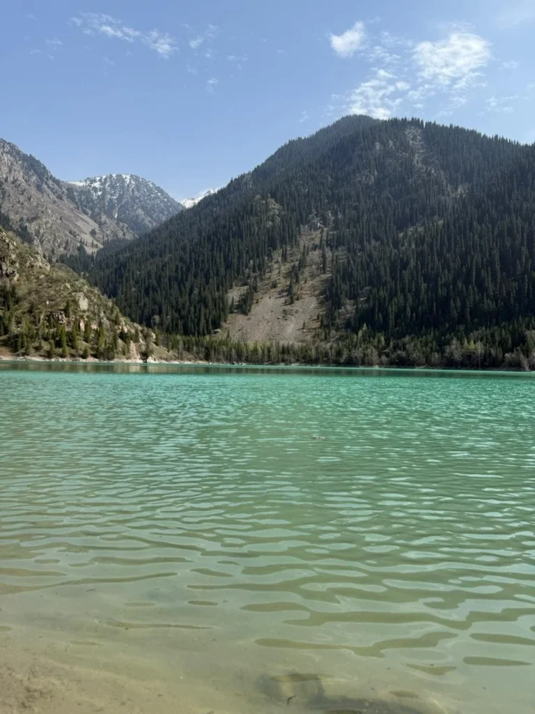 Panoramic view of Issyk Lake reflecting the Tian Shan mountains