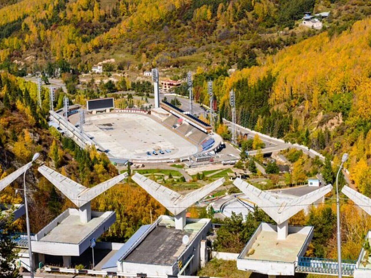 Aerial view of the Medeo skating rink surrounded by autumn forest